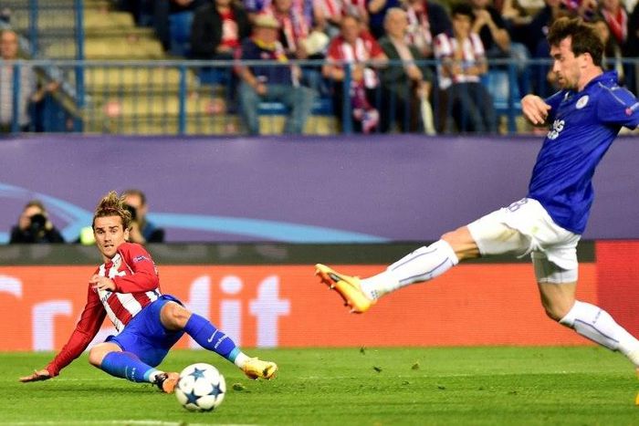Atletico Madrid forward Antoine Griezmann (L) curls a cross in past Leicester City defender Christian Fuchs during the Champions League quarter-final first leg at the Vicente Calderon stadium in Madrid on April 12, 2017