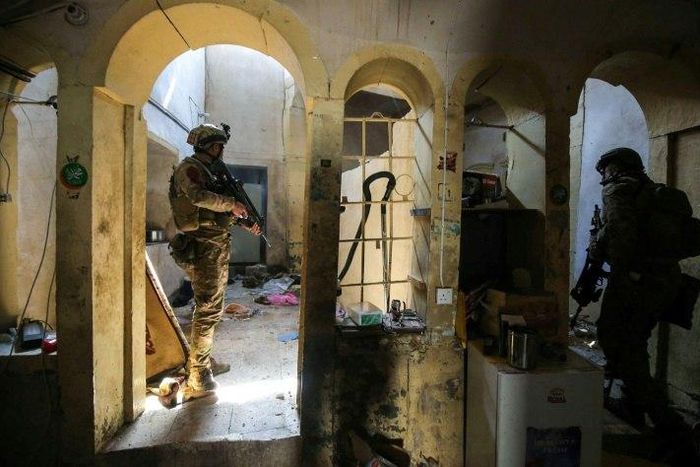 Iraqi forces advance in a house in the Old City of western Mosul as they press an offensive to retake the city from Islamic State group fighters