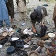 Afghan men examine the belongings of blast victims at the site of a series of explosions that targeted a funeral of a politician's son, who was killed during an anti-government protest a day earlier in Kabul