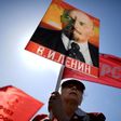 A Russian Communist party activist carries a banner with a portrait of late Soviet leader Vladimir Lenin during a May Day rally in central Moscow on May 1, 2017