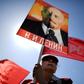 A Russian Communist party activist carries a banner with a portrait of late Soviet leader Vladimir Lenin during a May Day rally in central Moscow on May 1, 2017