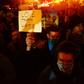 A demonstrator holds up a placard during a protest against Donald Trump's US presidential election victory at City Hall in Portland, Oregon on November 11, 2016