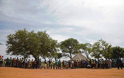 Newly arrived refugees from South Sudan queue in line waiting to be registered at Uganda's Ngomoromo border post