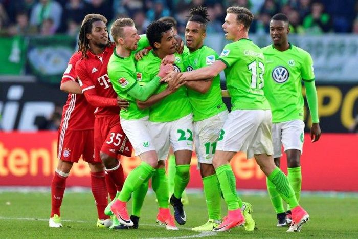 Wolfsburg's Brazilian midfielder Luiz Gustavo (C) and his teammates react after receiving the yellow and the red card during the German first division Bundesliga football match between VfL Wolfsburg and Bayern Munich on April 29, 2017