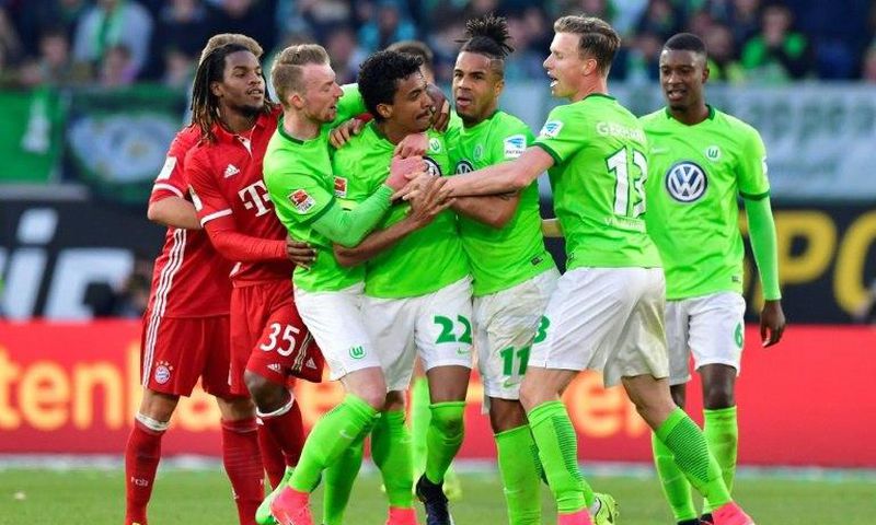 Wolfsburg's Brazilian midfielder Luiz Gustavo (C) and his teammates react after receiving the yellow and the red card during the German first division Bundesliga football match between VfL Wolfsburg and Bayern Munich on April 29, 2017