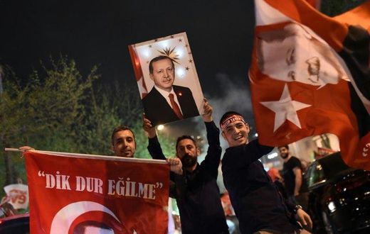 A supporter of the "Yes" campaign holds up a picture of Turkish president Recep Tayyip Erdogan during a rally near the headquarters of the conservative Justice and Development Party (AKP) in Istanbul on April 16, 2017 after initial results