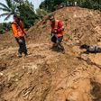 Indonesian rescuers use a sniffer dog to search for survivors after a wall of mud slammed onto houses from a hillside after heavy rainfall in Ponorogo district, East Java on April 2, 2017