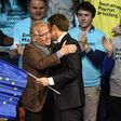 Emmanuel Macron clasps a EU flag as he hugs famous MEP Daniel Cohn-Bendit (L)