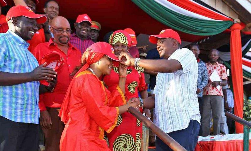 President Uhuru Kenyatta receives defectors during a public rally at Voi Stadium. Looking on is Dr Naomi Shaban.