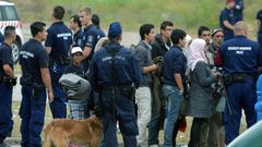 Asylum-seekers wait to board a bus at their temporary Hungarian home of Roszke on the Hungarian-Serbian border in June 2015
