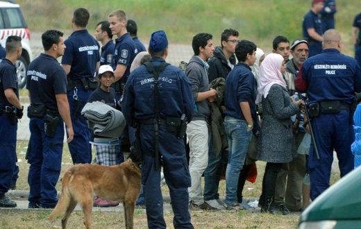 Asylum-seekers wait to board a bus at their temporary Hungarian home of Roszke on the Hungarian-Serbian border in June 2015