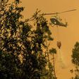 A firefighter helicopter helps try to put out a forest fire in Pumanque, 140 km south of Santiago on January 21, 2017