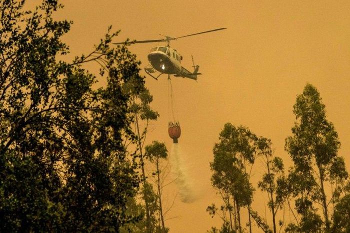 A firefighter helicopter helps try to put out a forest fire in Pumanque, 140 km south of Santiago on January 21, 2017