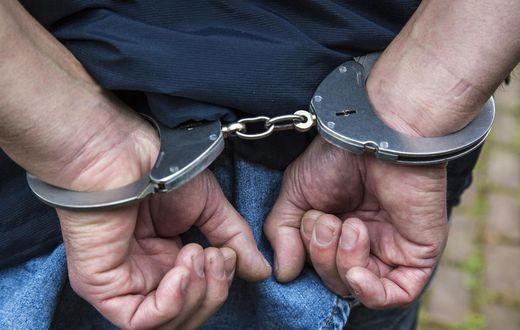 A handcuffed suspect arrested during a past event (Twitter)