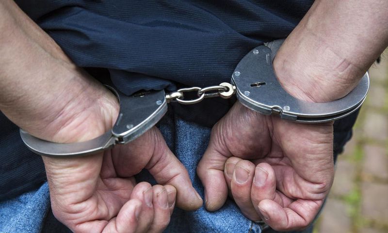 A handcuffed suspect arrested during a past event (Twitter)