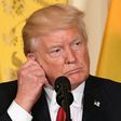 US President Donald Trump adjusts his translation ear piece during a joint press conference with Colombia's President Juan Manuel Santos at the White House on May 18, 2017 in Washington, DC