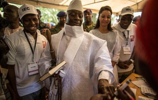 Incumbent Gambian President Yahya Jammeh (C) has his finger inked before casting his marble in a polling station in Banjul on December 01, 2016
