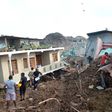 Residents and rescuers check damaged homes at the site of a collapsed garbage dump near Colombo, on April 15, 2017