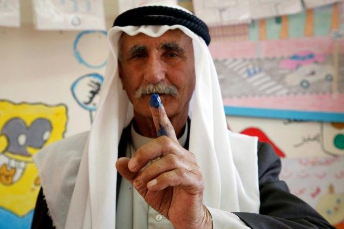 A Palestinian man shows his ink-stained finger after casting his ballot during municipal elections in the village of Yatta in the West Bank on May 13, 2017
