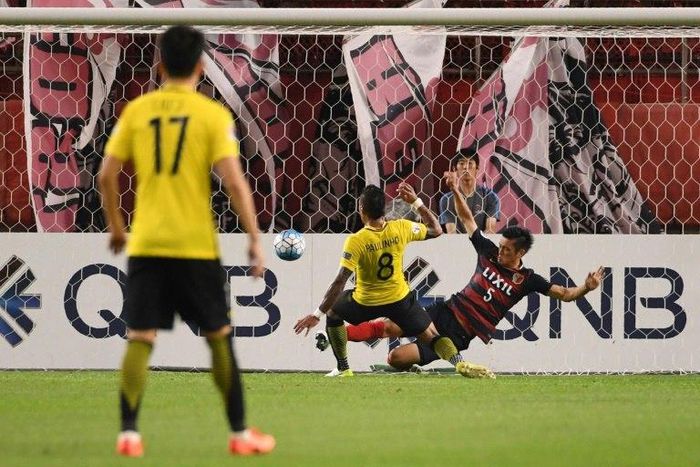 Guangzhou Evergrande's midfielder Paulinho scores a goal past Kashima Antlers' defender Naomichi Ueda during the AFC Champions League football match between Japan's Kashima Antlers and China's Guangzhou Evergrande on May 30, 2017
