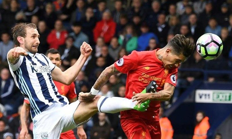 Liverpool's Roberto Firmino heads the opening goal past West Bromwich Albion's Craig Dawson during the English Premier League match at The Hawthorns in West Bromwich, central England, on April 16, 2017