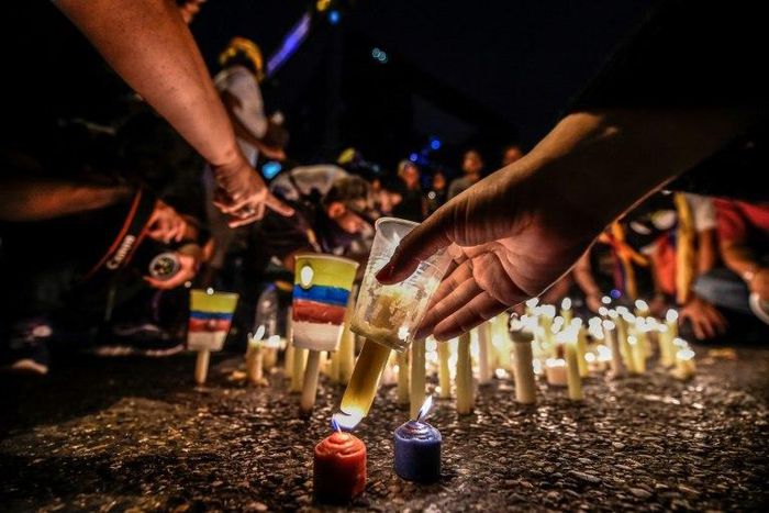 Opposition activists place candles to protest against the deaths of 43 people in clashes with the police during weeks of anti-government demonstrations
