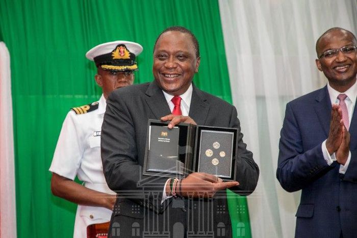 President Uhuru Kenyatta displays a set of the new currency Kenyan coins during their launch in December 2018 (PSCU)
