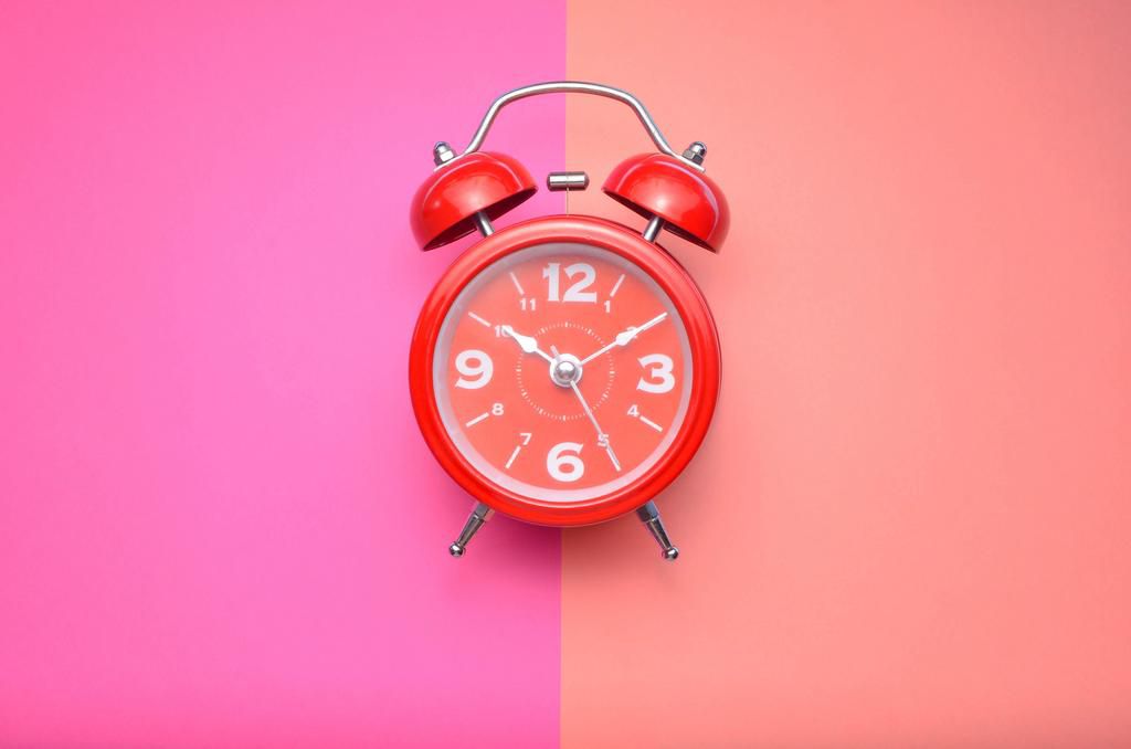 Close-Up Of Alarm Clock Over Colored Background