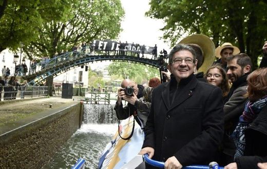 French presidential election candidate for the far-left coalition La France insoumise Jean-Luc Melenchon (L), stands aboard an "unbowed" barge on the Canal Saint-Martin on April 17, 2017 in Paris