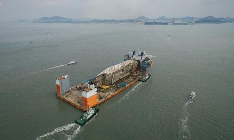The lifting ship carrying the wreck was escorted by a smaller boat carrying relatives of the nine missing, as well as other patrol craft