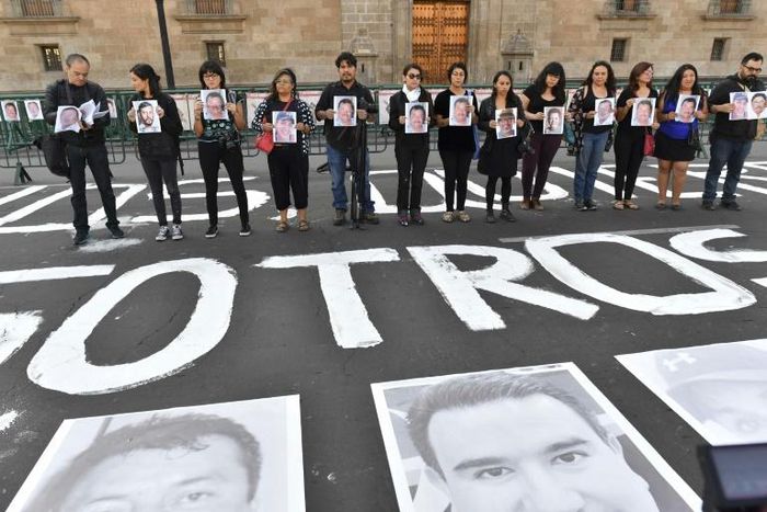 Members of the press hold images of colleagues during a protest against the murder or disappearance of journalists and photojournalists in Mexico, in front of the National Palace in Mexico City on June 1, 2018