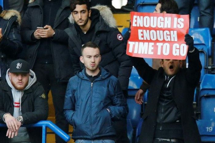 An Arsenal fan holds up a banner calling on Arsenal's French manager Arsene Wenger to quit during the English Premier League football match between Chelsea and Arsenal at Stamford Bridge in London on February 4, 2017