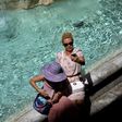 Tourists takes selfies by the Trevi Fountain in Rome