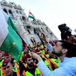 People protest as police officers stand guard in front of the parliament building in Budapest on April 4, 2017