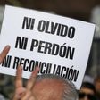 A demonstrator holds a sign reading in Spanish "Neither forget nor forgive, nor reconciliation", during the Madres de Plaza de Mayo human rights group's weekly demonstration at the Plaza de Mayo square in Buenos Aires on May 4, 2017