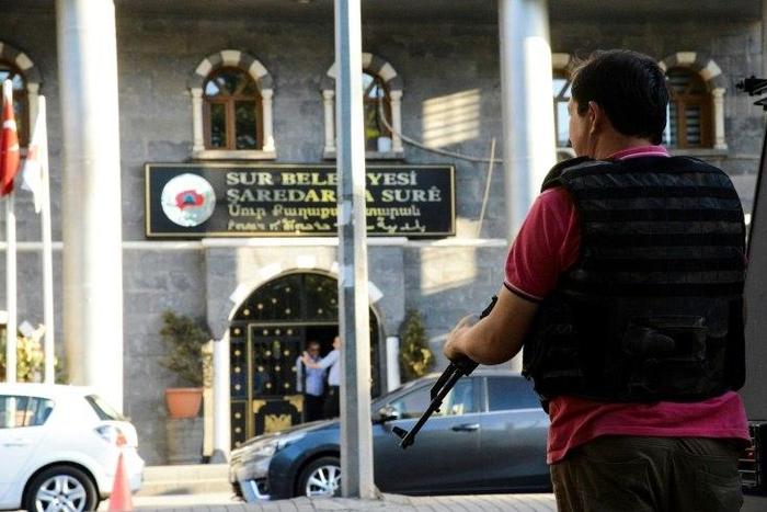 A Turkish policeman stands guard at the Sur municipality building during a police operation