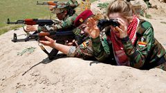 An Iraqi Kurdish female fighter and a Yazidi female fighter aim their weapons near the front line of the fight against ISIS near Mosul, Iraq, April 20, 2016.