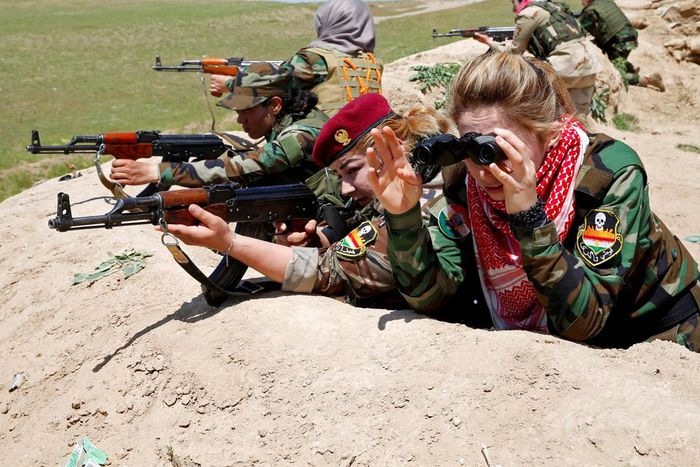 An Iraqi Kurdish female fighter and a Yazidi female fighter aim their weapons near the front line of the fight against ISIS near Mosul, Iraq, April 20, 2016.