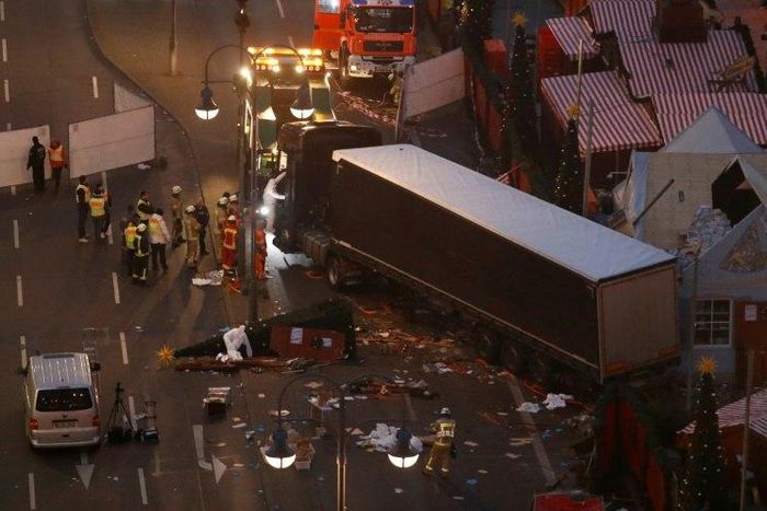 Forensic experts examine the scene around a truck that crashed into a Christmas market on December 20, 2016 in Berlin