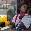 Water carrier LŽo (left) fills up a jerrycan in Antananarivo. Campaign group WATERAID says 65 percent of Madagascar's rural population live without access to clean water