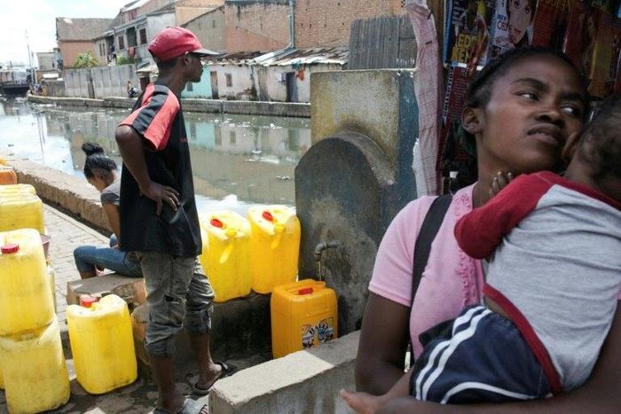 Water carrier LŽo (left) fills up a jerrycan in Antananarivo. Campaign group WATERAID says 65 percent of Madagascar's rural population live without access to clean water