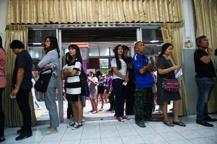 People queue up to cast their ballot during early voting in Bangkok on Sunday