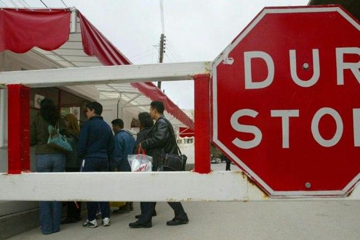 Turkish and Greek Cypriots have their passports checked before crossing a checkpoint on the Turkish side of the Green Line that divides the Cypriot capital Nicosia on February 10, 2004