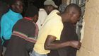 Residents of Nakuru Town West peep through the window of a house where a woman was killed by her lover.