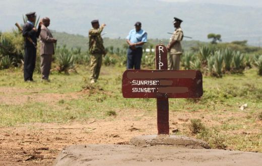 Kenyan police near a grave
