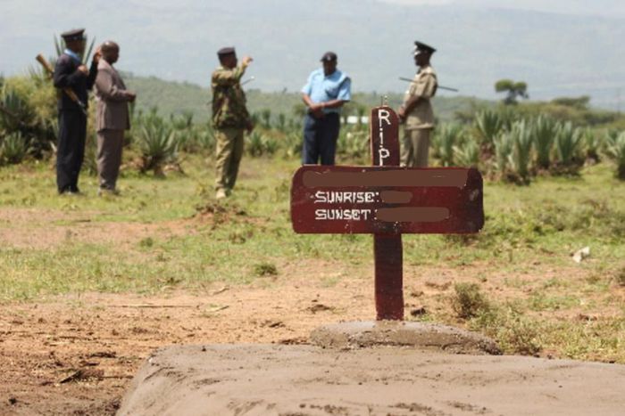 Kenyan police near a grave