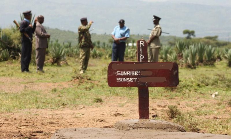 Kenyan police near a grave