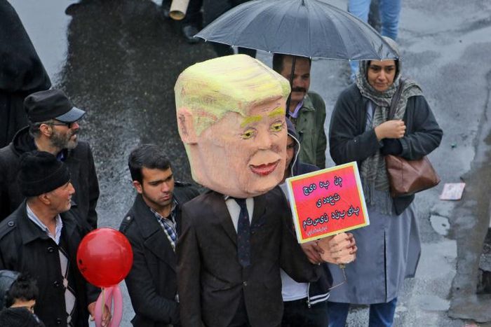 An Iranian man carries an effigy depicting US President Donald Trump carrying a sign reading in Persian "I am not bound by any commitment" during a ceremony celebrating the 40th anniversary of the Islamic Revolution in Tehran on February 11, 2019