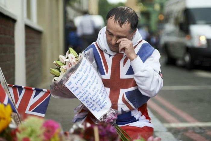 A man lays flowers at a makeshift memorial near Borough Market in London