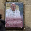A woman walks past an anti-Pope Francis poster featuring a portrait of the pontiff and a critical message ending "Where's your mercy?" in central Rome on February 6, 2017